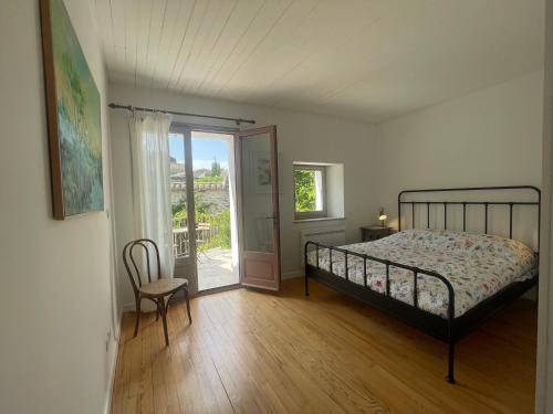 a bedroom with a bed and a sliding glass door at Chez Marie in Grignan