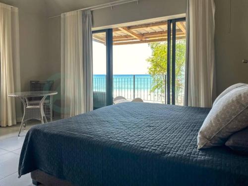 a bedroom with a bed and a view of the ocean at Beachfront villa by M&H in Tamarin