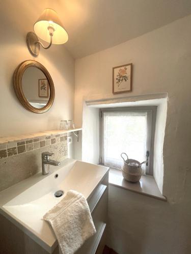 a bathroom with a sink and a mirror and a window at Chez Marie in Grignan