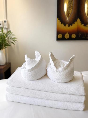 a pair of white towels sitting on top of a bed at inghome & guesthouse in Chiang Mai