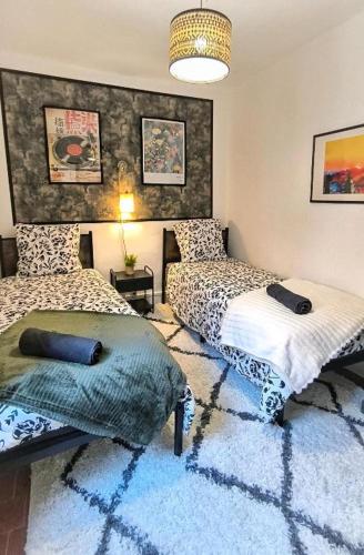 a bedroom with two beds and a blue rug at Maison de la Liberté - Petite maison à 4 étages in Nyons
