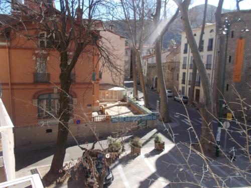 a view of a city street with trees and buildings at Poppys Chambres d'Hotes in Céret