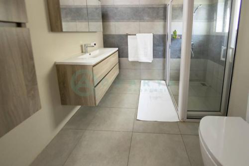 a bathroom with a shower and a sink and a toilet at Beachfront villa by M&H in Tamarin