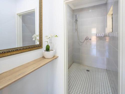 a bathroom with a shower with a mirror and a sink at Sage Haven Guesthouse in Modimolle