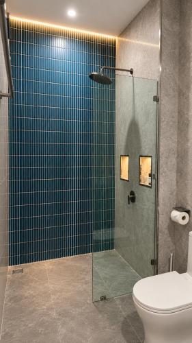 a bathroom with a glass shower with a toilet at Charis Tanjong Jara Villa Emerald in Dungun