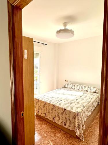 a bedroom with a bed and a window at Apartamento 1 minuto del mar in El Pozo del Esparto