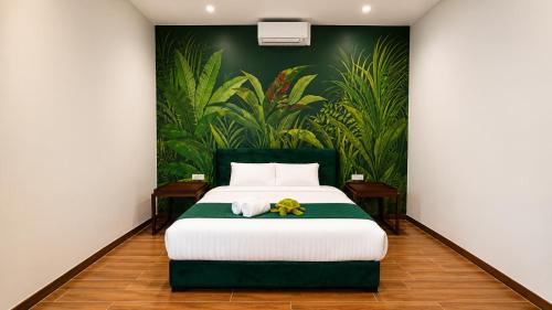 a bedroom with a large bed with a painting on the wall at Charis Tanjong Jara Villa Emerald in Dungun