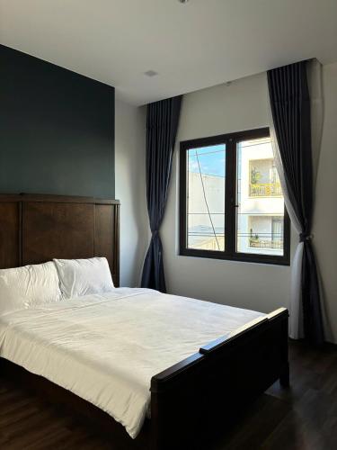 a bedroom with a large bed and a window at Doge Hotel in Quảng Ngãi