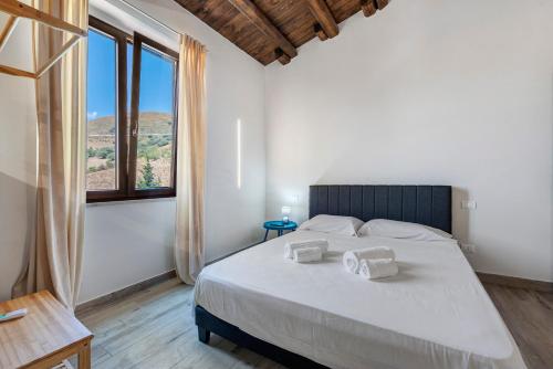 a bedroom with a large bed and a large window at Sikania Agrirelais in Caccamo