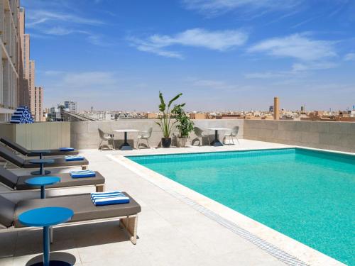 a swimming pool on the roof of a building at Novotel Riyadh Sahafa in Riyadh