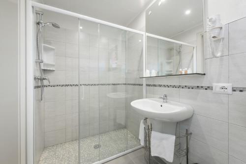 a white bathroom with a sink and a shower at Hotel Porta Palio in Verona