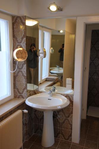 Ein Mann fotografiert ein Badezimmer mit Waschbecken. in der Unterkunft Villa Adrienne in Velden am Wörthersee