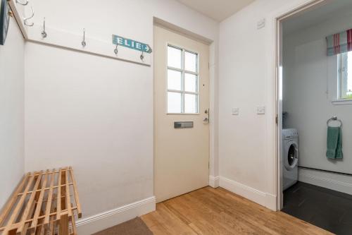 a laundry room with a door and a washer and dryer at Craiglea - Elie & Earlsferry in Earlsferry