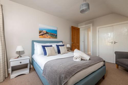 a bedroom with a large bed and a chair at Craiglea - Elie & Earlsferry in Earlsferry