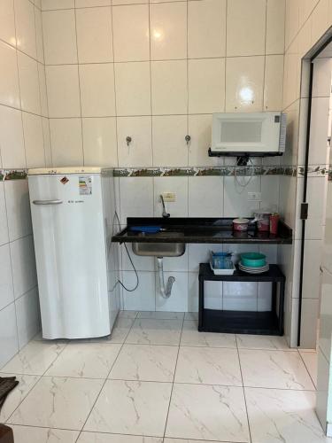 a small kitchen with a refrigerator and a microwave at Pousada Pesque Park in Boracéia