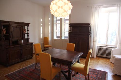 a dining room with a wooden table and yellow chairs at Villa Adrienne in Velden am Wörthersee