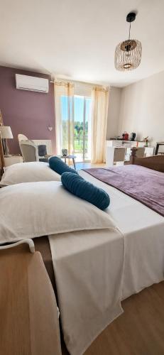 two beds in a room with two blue pillows on them at Chambre des Alpilles in Eygalières