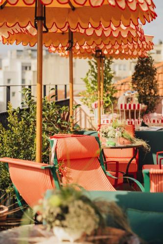 a patio with tables and chairs and an umbrella at Wilde Porto, Clerigos in Porto