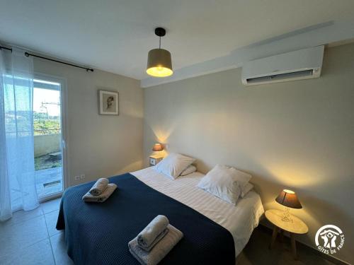 a bedroom with a large bed with towels on it at Le rêve bleu in Collioure