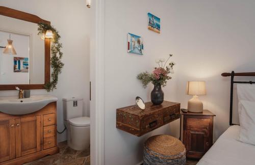 a bathroom with a sink and a toilet and a mirror at Villa Kyma in Aegina
