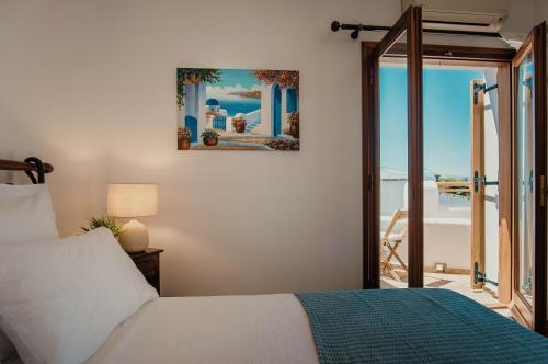 a bedroom with a bed and a view of the ocean at Villa Kyma in Aegina