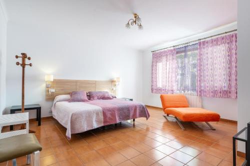 a bedroom with a bed and a chair and a window at Estrel in Can Picafort