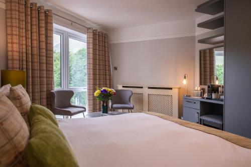 a hotel room with a bed and a desk and chairs at Delphi Resort Hotel & Spa in Leenaun