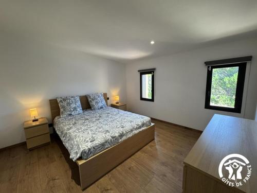 a bedroom with a bed and two night stands at Les mains du soleil in Millas