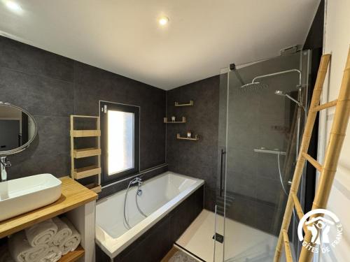 a bathroom with a tub and a shower and a sink at Les mains du soleil in Millas