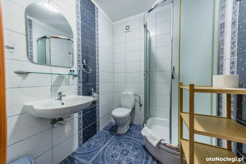 a bathroom with a sink and a toilet and a mirror at LUNA Baltica in Rewal