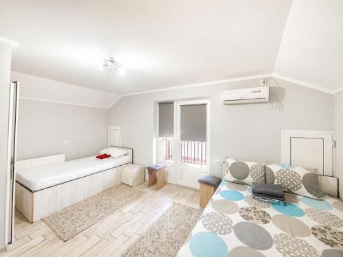a white room with a bed and a couch at Hotel Dulgher in Giurgiuleşti