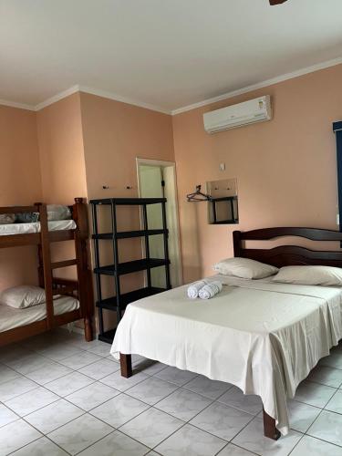 a bedroom with two beds and a bunk bed at Pousada Pesque Park in Boracéia