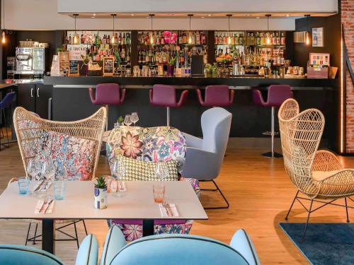 a restaurant with two tables and chairs and a bar at Novotel Dijon Sud in Dijon