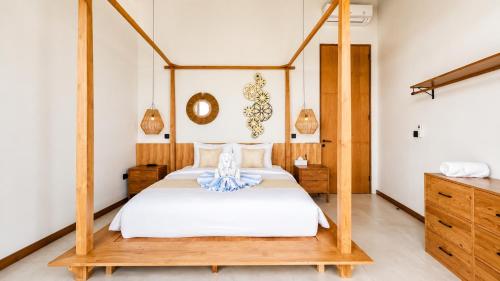 a bedroom with a bed with a wooden frame at 4Bedroom Umah Jeng Alessia Villa - Pererenan by SooBali in Munggu