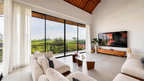 a living room with white furniture and a large window at 4Bedroom Umah Jeng Alessia Villa - Pererenan by SooBali in Munggu