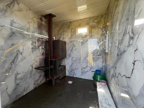 a bathroom with a marble wall with a shower at Kambar-ata yurt camp in Song-Kul
