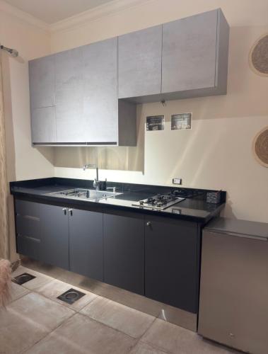 a kitchen with black and white cabinets and a sink at Amarillis lb 