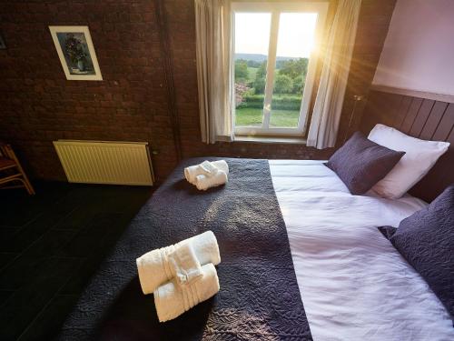 a bedroom with a large bed with towels on it at Appartement met panorama-uitzicht op het Geuldal, terras, Vijlen in Vijlen