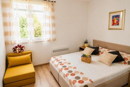 a bedroom with a bed and a yellow chair at Casa Ondina - Private House with Jacuzzi & Big Garden in Central Istria in Šumber