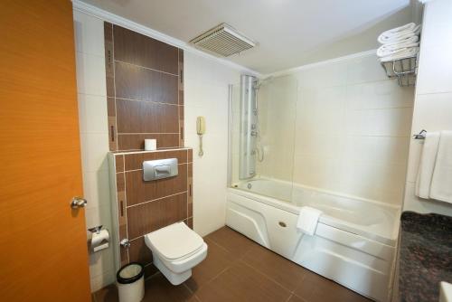 a bathroom with a toilet and a bath tub at Surmeli Adana Hotel in Adana
