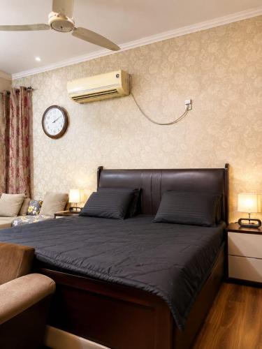 a bedroom with a bed and a clock on the wall at 6Bedroom Villa DHA Lahore in Lahore