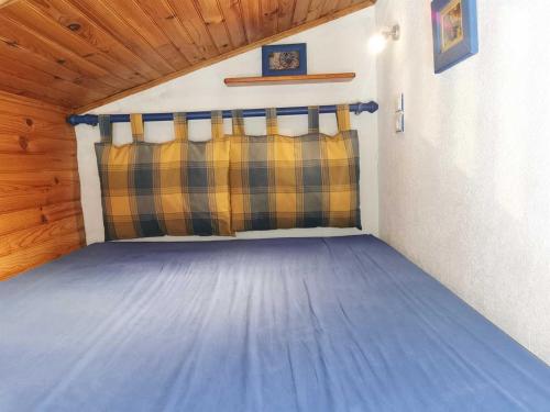 a bedroom with a blue bed in a cabin at Les lauriers in Sahorre