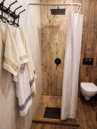 a bathroom with a shower with white towels and a toilet at Студия у чистейшего Моря! in Gonio