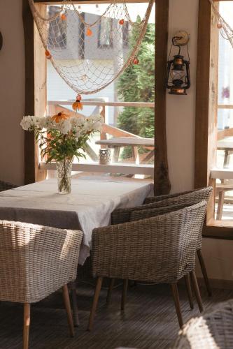 a table with chairs and a vase of flowers on it at Villa Marika Holiday Centre in Alajõe