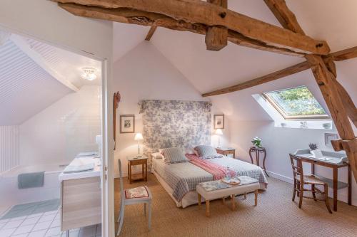 une chambre avec un lit et un bureau dans une pièce dans l'établissement Le Clos-Lascazes maison d'Hôtes, au Buisson de Cadouin