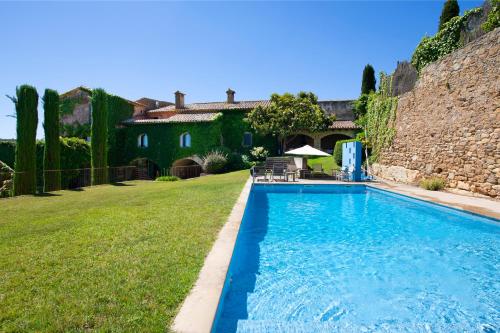 a swimming pool in the yard of a house at Casa Rufina, Exclusive & Charming Stone House in Costa Brava in Pals
