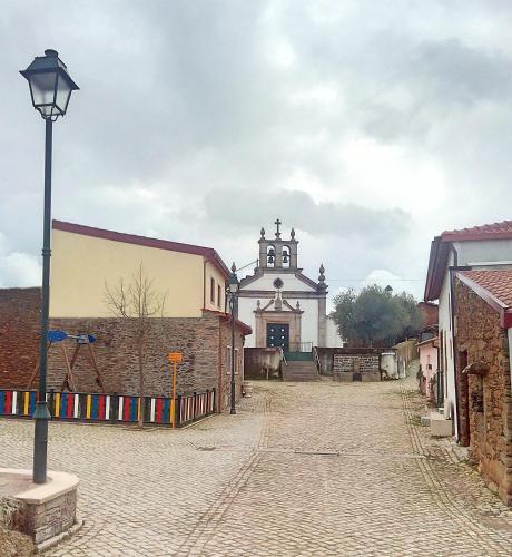 a street in front of a church with a street light at Casa do Azibo in Santa Combinha