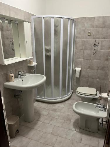 a bathroom with a shower and two sinks and a toilet at Casa Vacanze ai Valentini in Castelletto Soprano