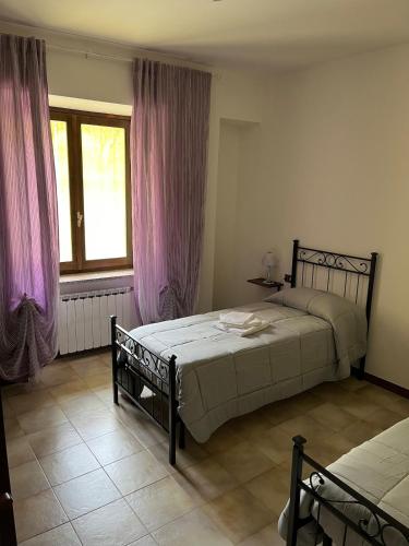 a bedroom with two beds and a window at Casa Vacanze ai Valentini in Castelletto Soprano