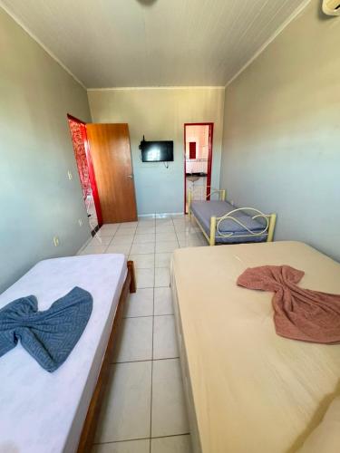 a room with two beds and a tv in it at Pousada Marialva in Barreiras